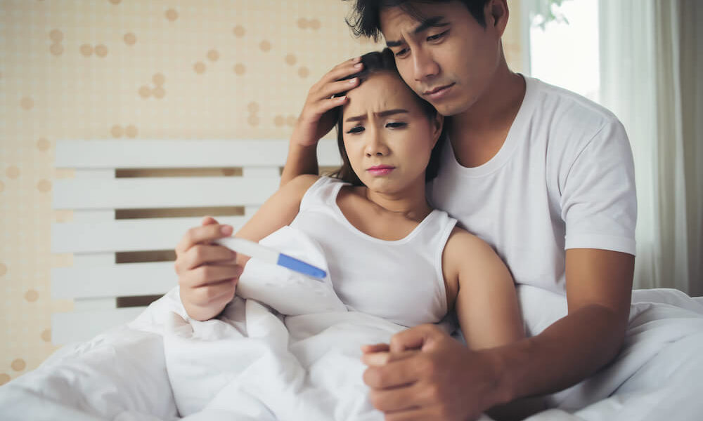 helpless parent holding pregnancy test kit for infertility